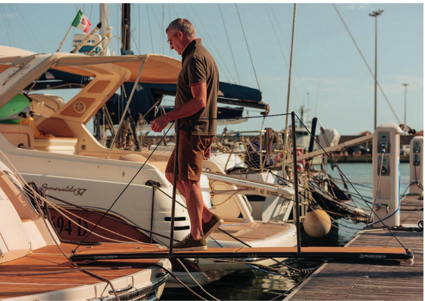 Hombre bajando de su barco al pantalán por una pasarela Aguacarbon EasyWay de fibra de carbono
